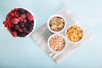 Mixed cereals in the blue bowl with fruit on the blue table, top