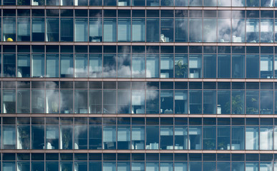 Obraz na płótnie Canvas Fassade eines Bürogebäudes mit Wolkenspiegelung