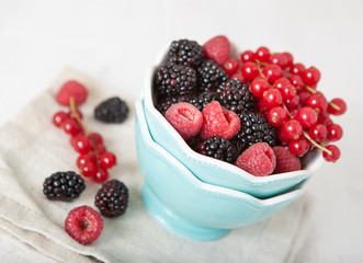 Fresh berries in the bowl on the white table