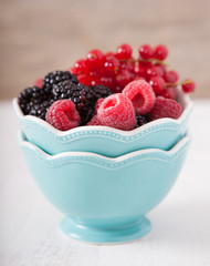 Fresh berries in the bowl on the white table