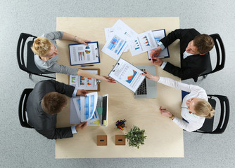 Top view of office workers sitting at a table for meetin