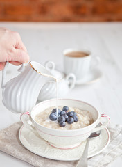 Healthy breakfast: oats porridge with coffee on the table