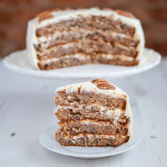 A piece of Hummingbird cake with pecans and cream cheese frosting