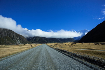 Access to the Tasman Valley of Aoraki Mount Cook National Park, is a gravel road. A long big cloud rounding the mountains is usually seen in the area.