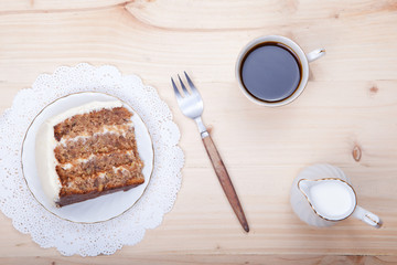 A piece of pecan cake with white buttercream icing, view from above