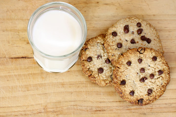 snack: glass of milk and chocolate chip cookies on grey background