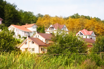 Fototapeta na wymiar Cottage houses in picturesque autumn forest