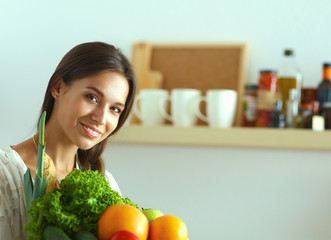 Young woman holding grocery shopping bag with vegetables 