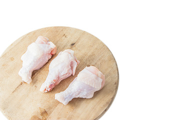 raw chicken legs on wooden cutting boards on white background