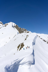 Obraz premium Snowboarders walking uphill for freeride