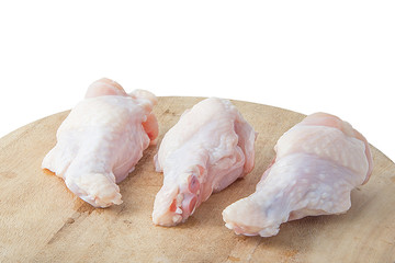 raw chicken legs on wooden cutting boards on white background