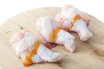 raw chicken legs on wooden cutting boards on white background