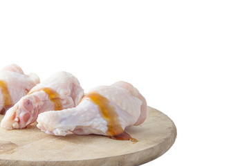 raw chicken legs on wooden cutting boards on white background
