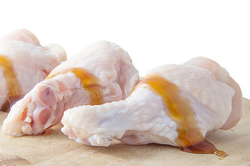 raw chicken legs on wooden cutting boards on white background