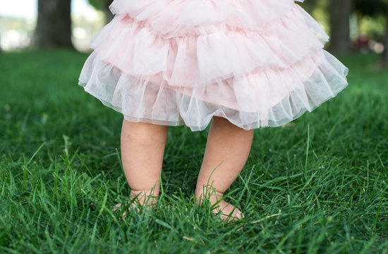 Little baby feet on fresh green grass outdoors