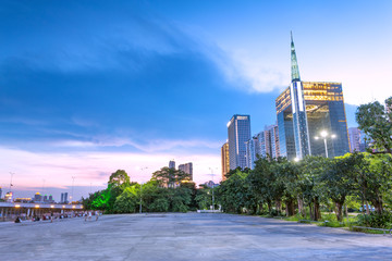 Fototapeta premium skyscrapers of a modern city at dusk with street lamps