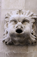 Fototapeta na wymiar Marble basrelief depicting an odd face