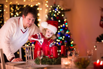 Father and daughter lighting Christmas candles