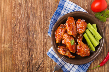 Baked chicken wings in honey sauce sprinkled with sesame seeds.