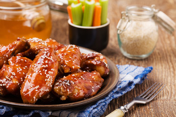 Baked chicken wings in honey sauce sprinkled with sesame seeds.