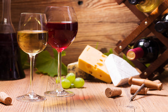 Glasses of red and white wine, served with grapes and cheese