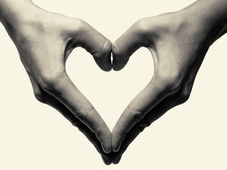 Black and white toned photo with two hands portraying heart