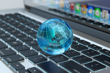 Fototapeta Global computer network communication, internet business and marketing concept, blue transparent Earth globe on laptop keyboard macro view obraz
