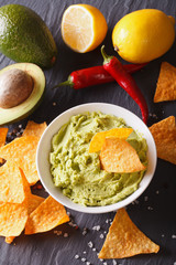 sauce guacamole, nachos chips close-up and ingredients. vertical
