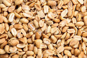 Roasted peanuts salted on crumpled paper and old wooden table.