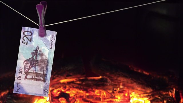 Falschgeld trocknet auf Leine vor dem Kaminfeuer