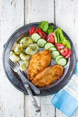 Fried chicken steak,boiled potatoes and vegetable salad 