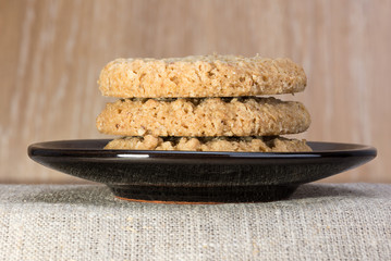 oatmeal cookies lie on a black saucer