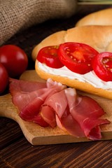 Slice of smoked ham in front of baguette with cottage