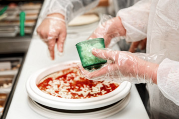 Culinary student is cooking pizza