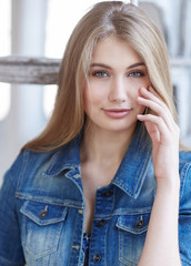 Portrait of blond female in denim jeans jacket.