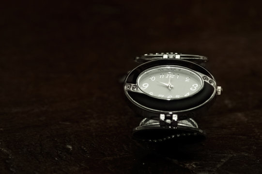 Orologio con Bracciali eleganti da donna in primo piano vista dall'alto sfondo legno