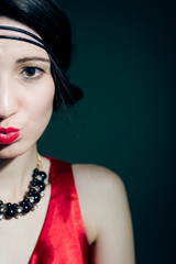Closeup of elegant young woman wearing 1920s styled red costume 