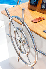 Sailing yacht control wheel and navigation implement.