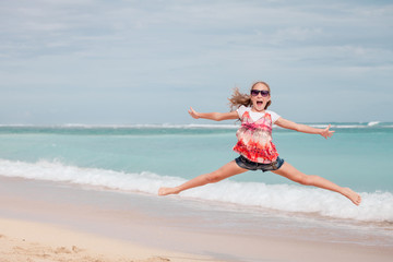 Happy teen girl  jumping on the beach