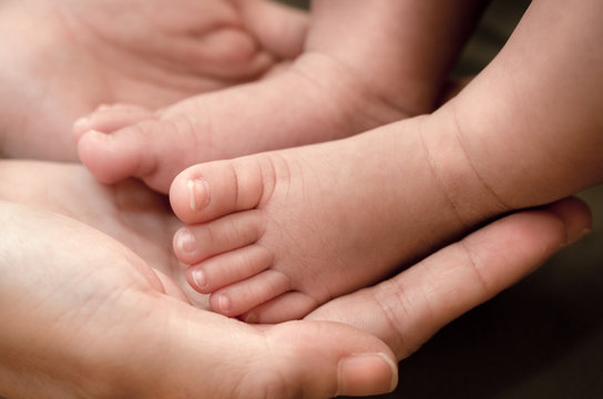 Baby's foot in mother hands, Soft and selective focus