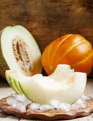 Fresh melon with ice on a wooden board, selective focus