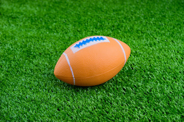 Toy football on artificial grass background