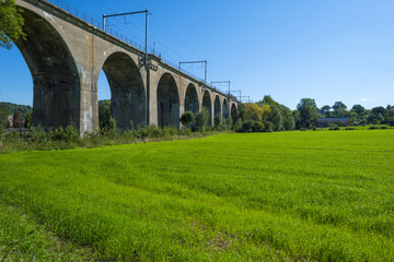 Railway viaduct along a meadow in summer