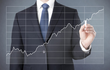 Businessman drawing a growing chart with chalk