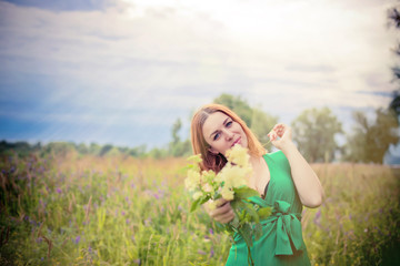 Romantic red-haired young woman in green long dress Walking