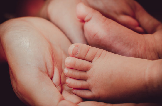 Love, Baby's foot in mother hands, Soft and selective focus