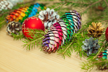 Christmas decoration on the wooden background. Christmas tree, toys, Christmas cones painted in different colors