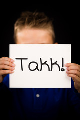 Child holding sign with Norwegian word Takk - Thank You