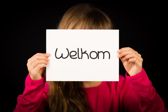Child holding sign with Dutch word Welkom - Welcome
