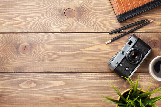 Camera and supplies on office wooden desk